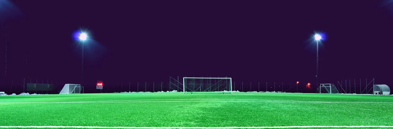 Cancha de fútbol vacía con las luces encendidas de noche